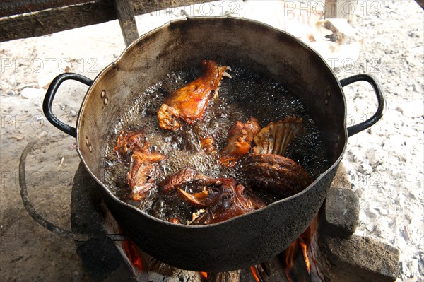 Slaughtered and dissected dogs being fried in hot oil