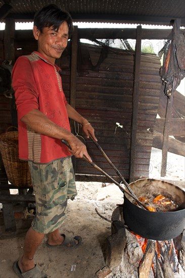 Man frying slaughtered and dissected dogs in hot oil