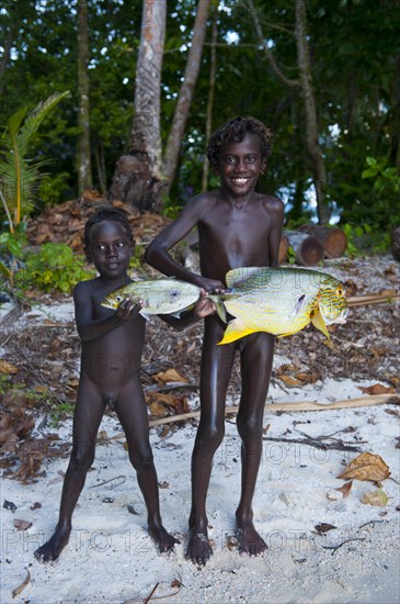 Boys proudly showing the fish they caught