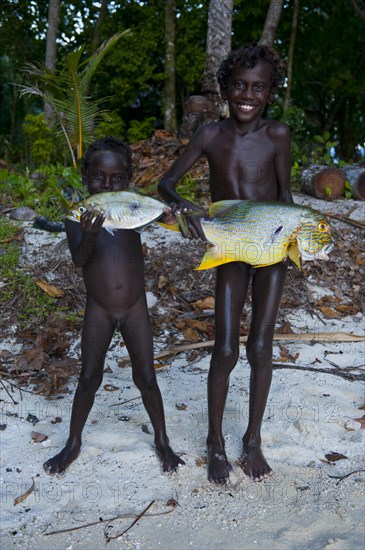 Boys proudly showing the fish they caught