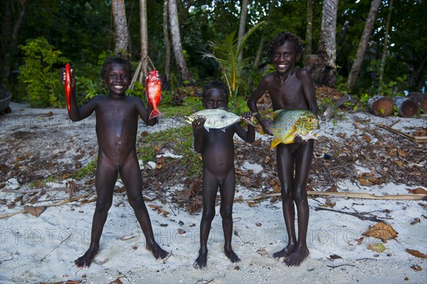 Boys proudly showing the fish they caught