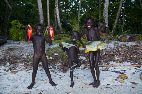 Boys proudly showing the fish they caught