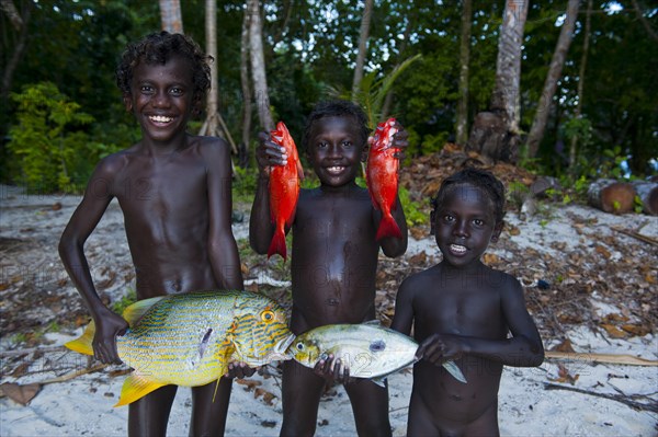 Boys proudly showing the fish they caught