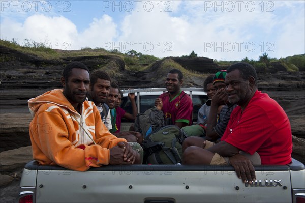 People on a pickup driving through the volcanic ash of Mount Yasur volcano