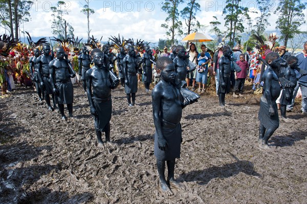 Members of a tribe covered in black paint at the traditional sing-sing gathering