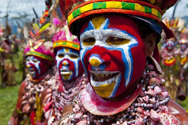 Members of a tribe in colourfully decorated costumes with face paint at the traditional sing-sing gathering