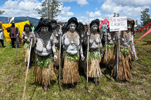 Women in colourfully decorated costumes with face and body paint at the traditional sing-sing gathering