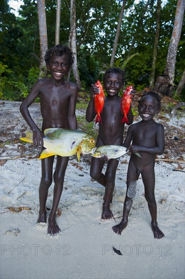 Boys proudly showing the fish they caught