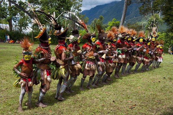 Tribal members in colourful decorations and face paint are celebrating at the traditional Sing Sing gathering in the highlands