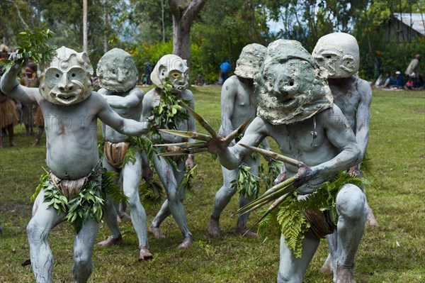 Tribal members in masks and full body paint are celebrating at the traditional Sing Sing gathering in the highlands