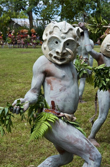 Tribal members in masks and full body paint are celebrating at the traditional Sing Sing gathering in the highlands