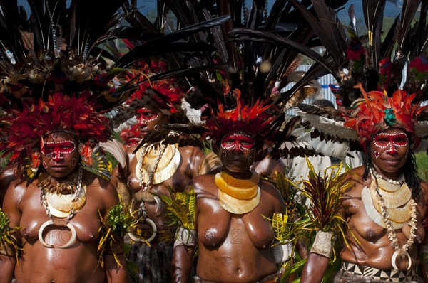 Women in colourfully decorated costumes with face paint at the traditional sing-sing gathering