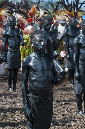 Members of a tribe covered in black paint at the traditional sing-sing gathering