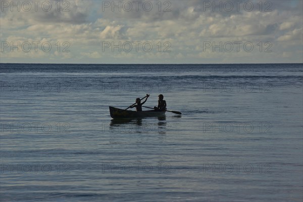 Boys in a canoe in backlight