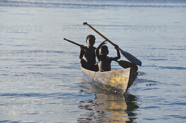 Boys in a canoe in backlight
