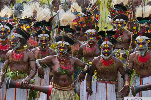 Members of a tribe in colourfully decorated costumes with face paint at the traditional sing-sing gathering