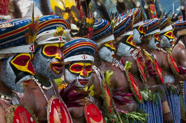 Members of a tribe in colourfully decorated costumes with face paint at the traditional sing-sing gathering