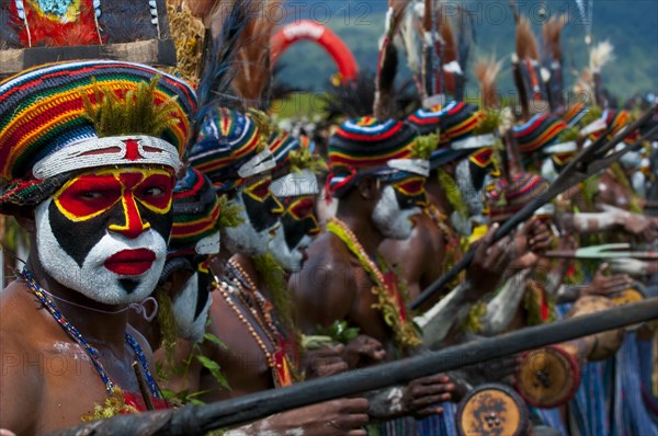 Members of a tribe in colourfully decorated costumes with face paint at the traditional sing-sing gathering