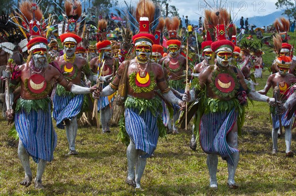 Members of a tribe in colourfully decorated costumes with face paint at the traditional sing-sing gathering