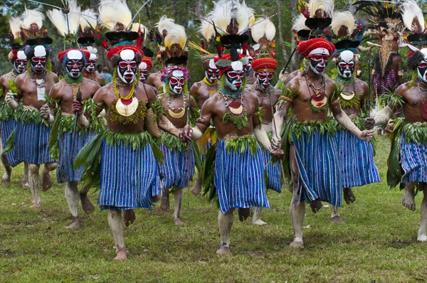 Men in colourfully decorated costumes with face paint are celebrating at the traditional Sing Sing gathering in the highlands