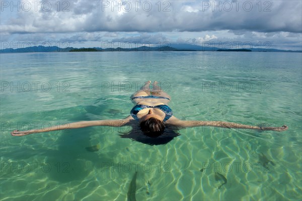 Tourist floating in the clear water of the Marovo Lagoon