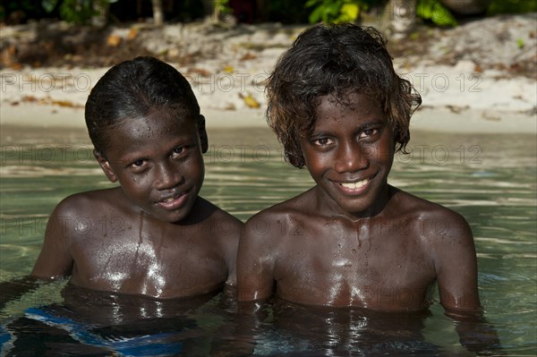 Smiling local boys in the water of the Marovo Lagoon