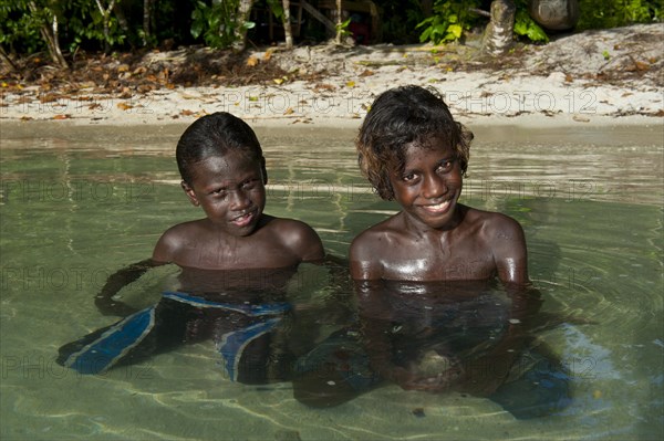 Smiling local boys in the water of the Marovo Lagoon