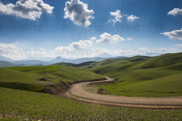 Road sneaking through the green hilly landscape