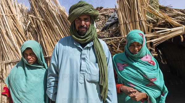 Tuareg family posing in front of their hut