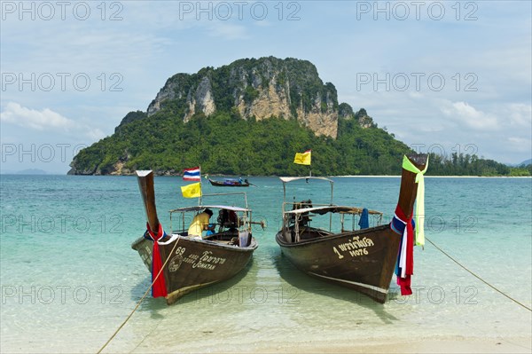 Two longtail boats on a beach