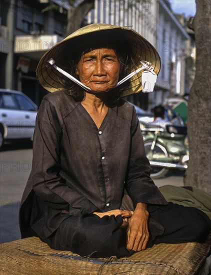 Elderly Vietnamese woman with a conical hat or Non La