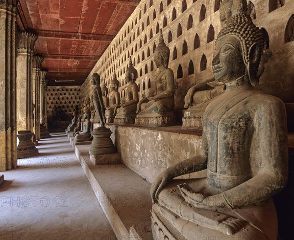 Ancient Buddha statues lining the walkway in the courtyard of Wat Si Saket Temple