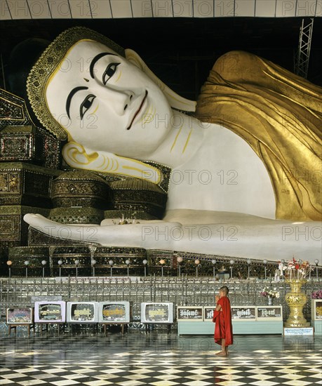 Buddhist monk standing in front of the Shwethalyaung-Buddha