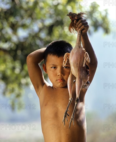 Akha boy presenting a plucked chicken