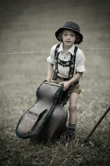 Young shepherd with a large bell during the Viehscheid cattle drive