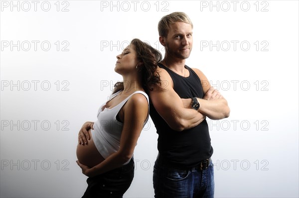 Woman with a pregnant belly leaning on man's shoulder