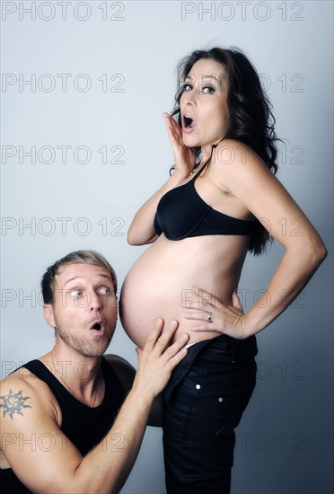 Man listening to the pregnant belly of his wife