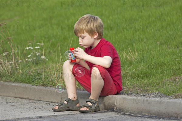 Young boy blowing bubbles