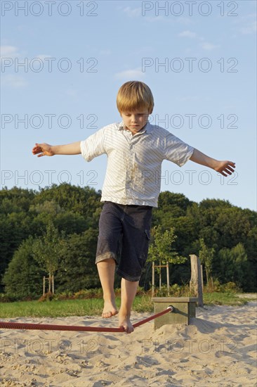 Young boy balancing on a rope in Egestorf Barefoot Park