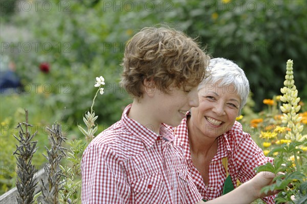 Grandmother and grandson are working together in the garden