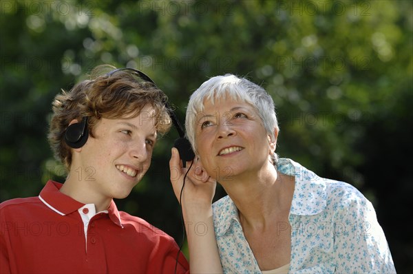 Grandma and grandson with headphones listening to music together