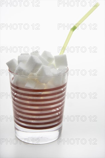 Glass filled with sugar cubes and a straw