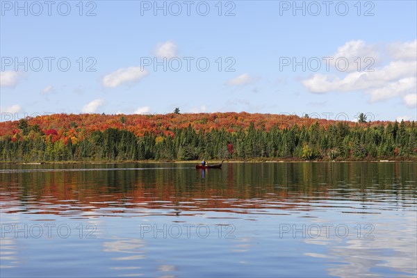 Canoe Lake with canoeists and a forest in autumn colours