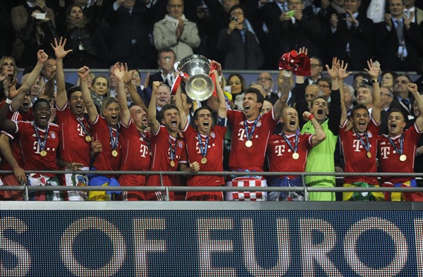 Team of FC Bayern cheering jubilantly with the trophy