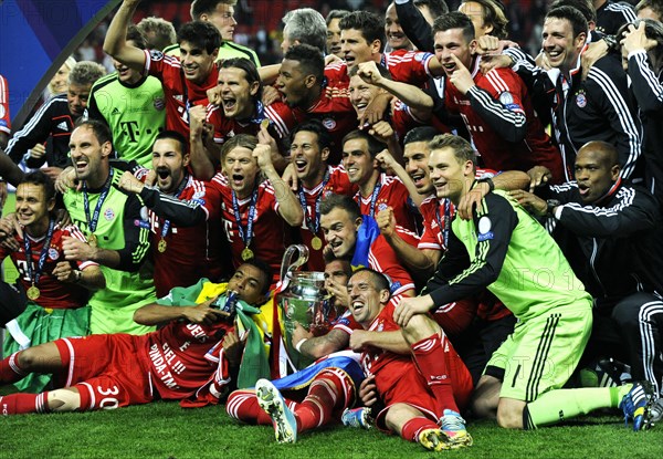 Team of FC Bayern cheering jubilantly with the trophy