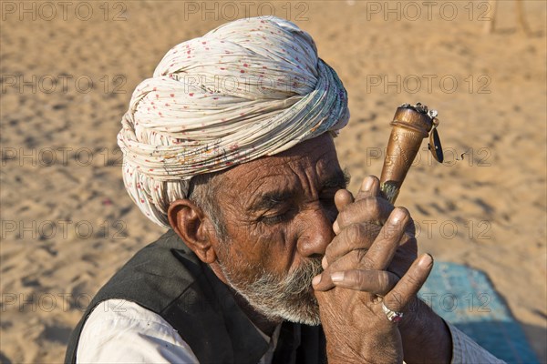 Indian man with a turban smoking a hash pipe