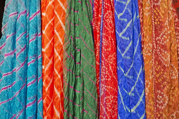 Colourful silk scarves are displayed for sale