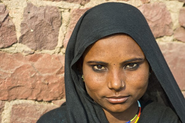 Young Indian woman wearing a black head scarf and a nose ring