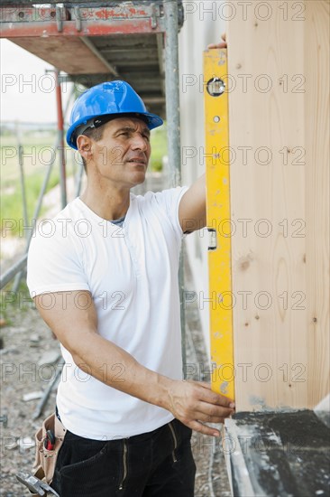Construction manager controlling the window installation with a spirit level
