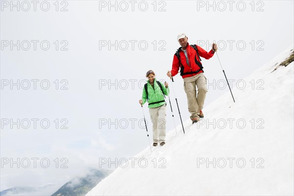 Couple moving over a snow field during their hike to Mt. Neunerkoepfle